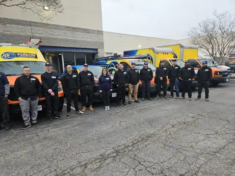 Team of HVAC professionals standing outside Fusion Virginia building.