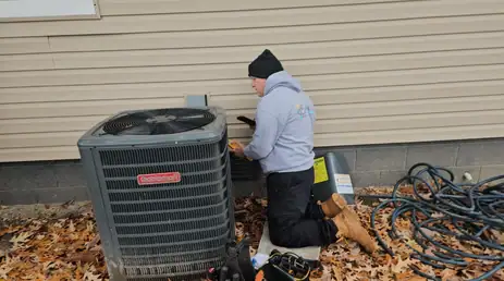 HVAC technician repairing an outdoor air conditioning unit outside a house.